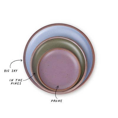 A stack of 3 plates in Dinner, Side, and Cake sizes in a periwinkle, muted forest green, and soft mauve purple colors.