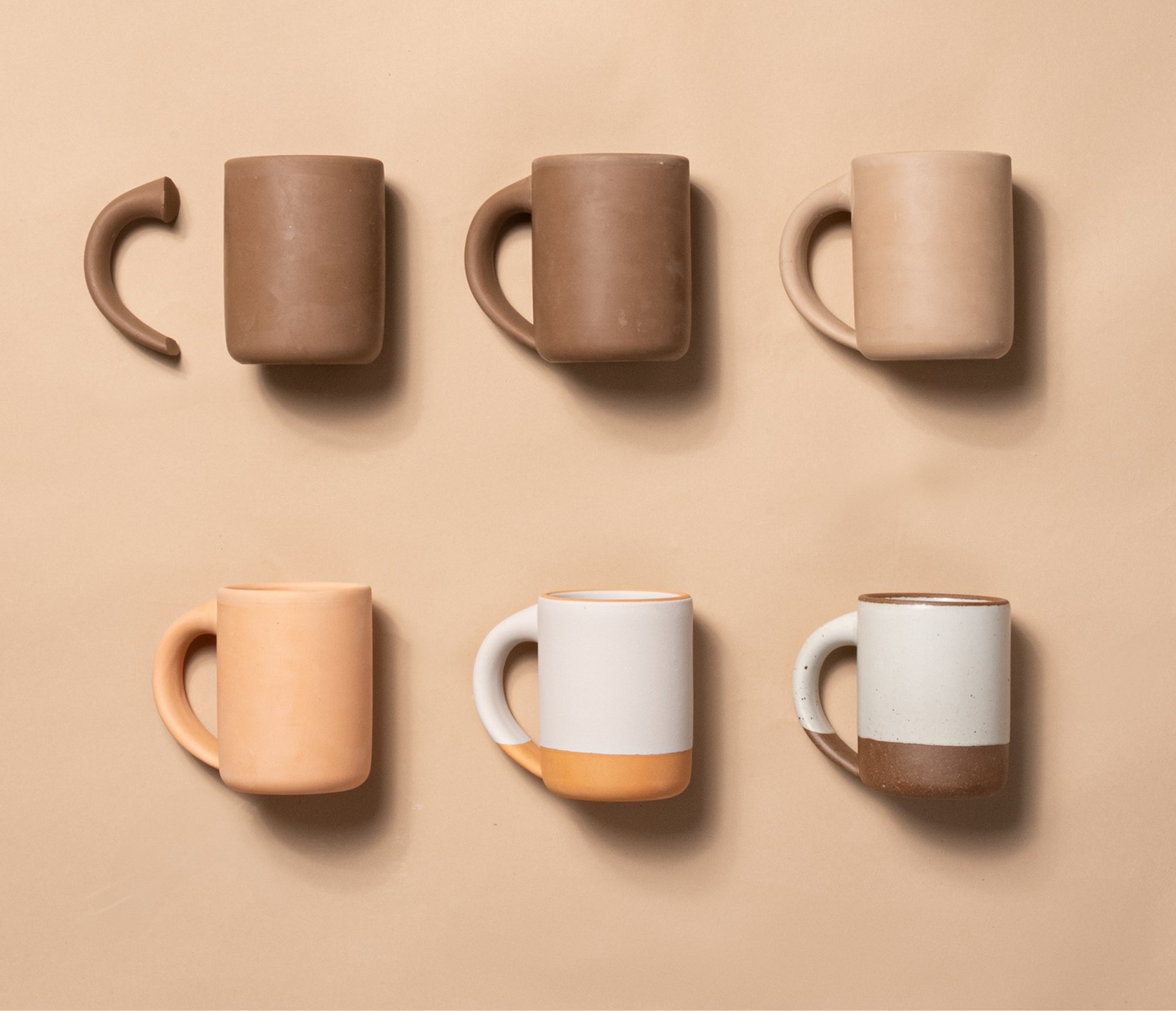 Five ceramic mugs and unfinished mug components arranged in two rows, showing neutral clay tones and finished two-tone glazes.