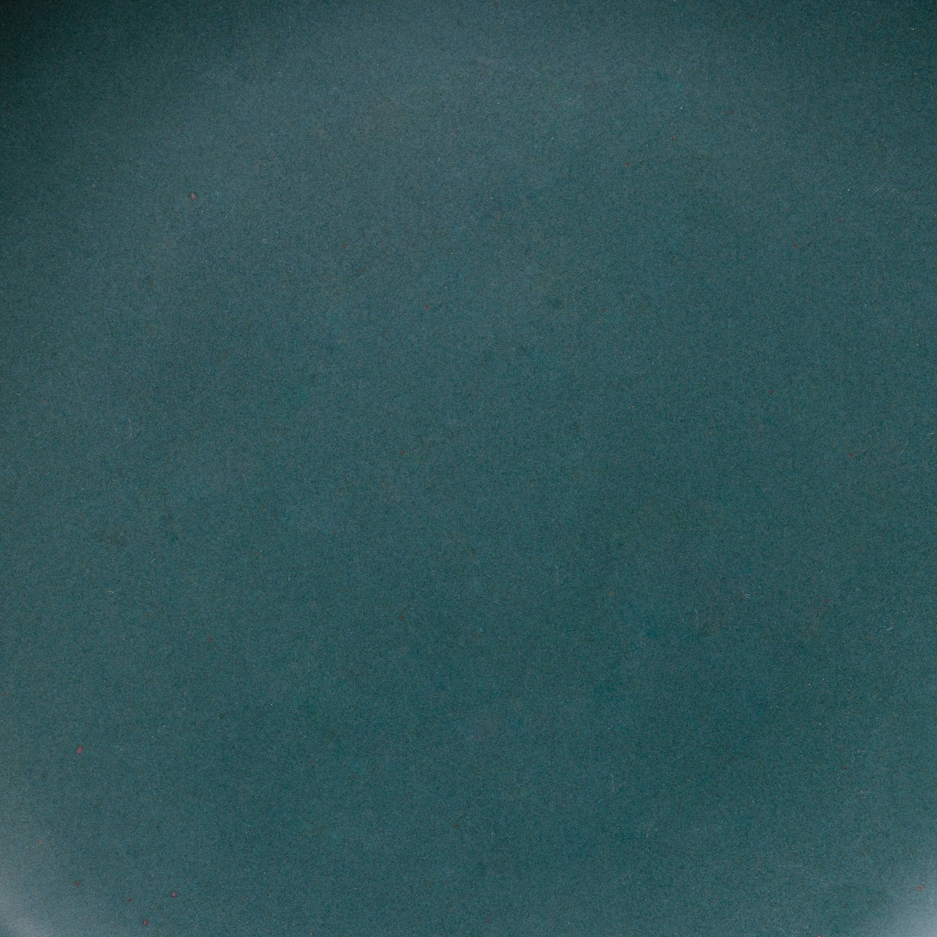 A closeup of a ceramic plate in a dark teal color