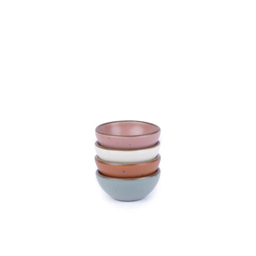 A stack of 4 tiny rounded ceramic bowls in a cool terracotta, warm off-white, blue-grey and dusty mauve pink featuring iron speckles and an unglazed rim
