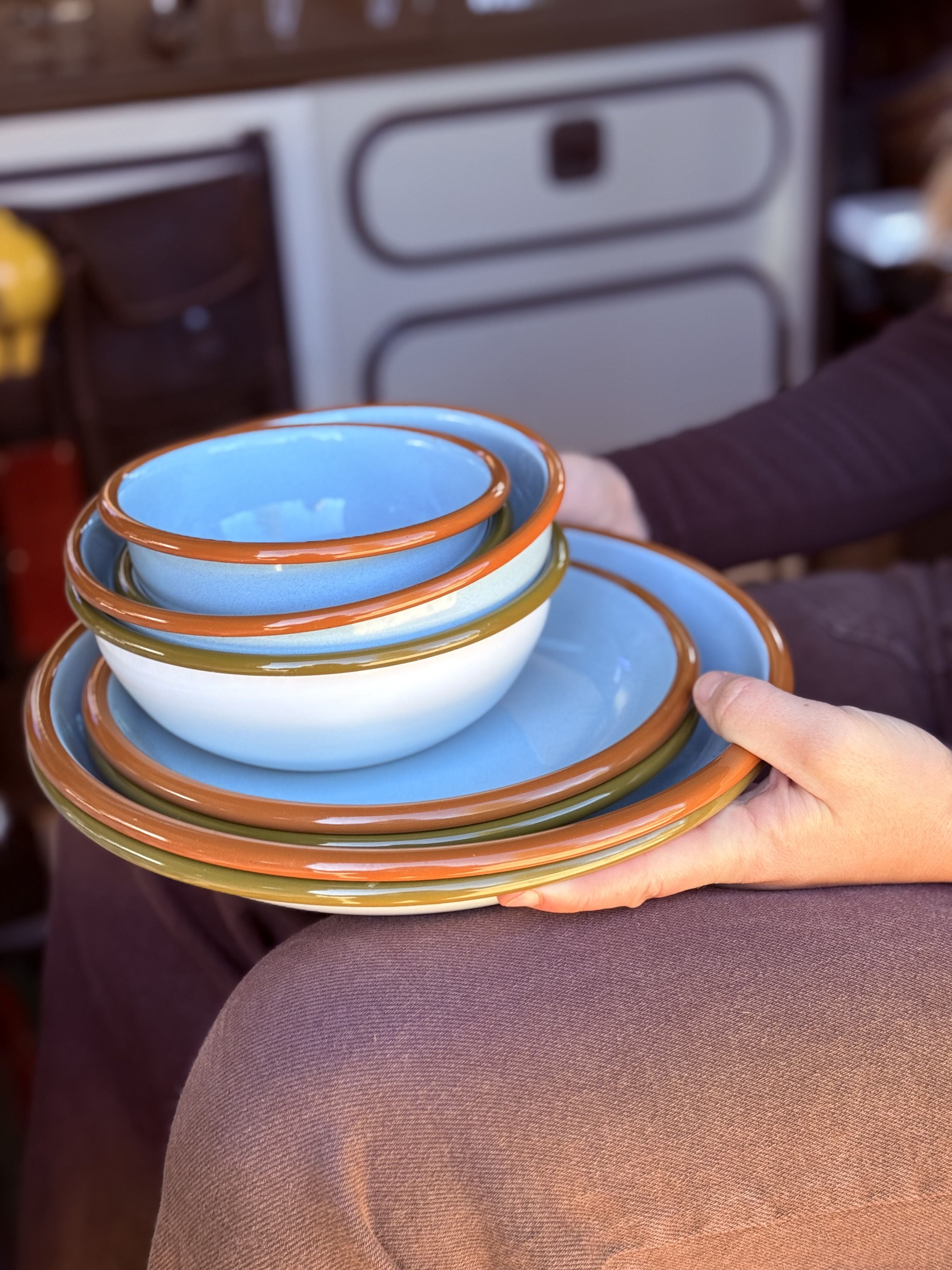 East Fork enamelware sits on top of a womans lap inside a VW Vanagon