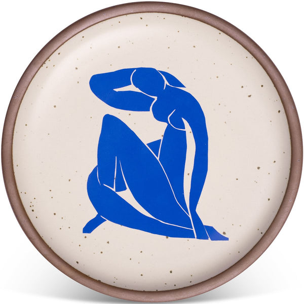 Cream-colored ceramic plate with a blue silhouette of a seated figure, featuring a speckled pattern and a brown rim.