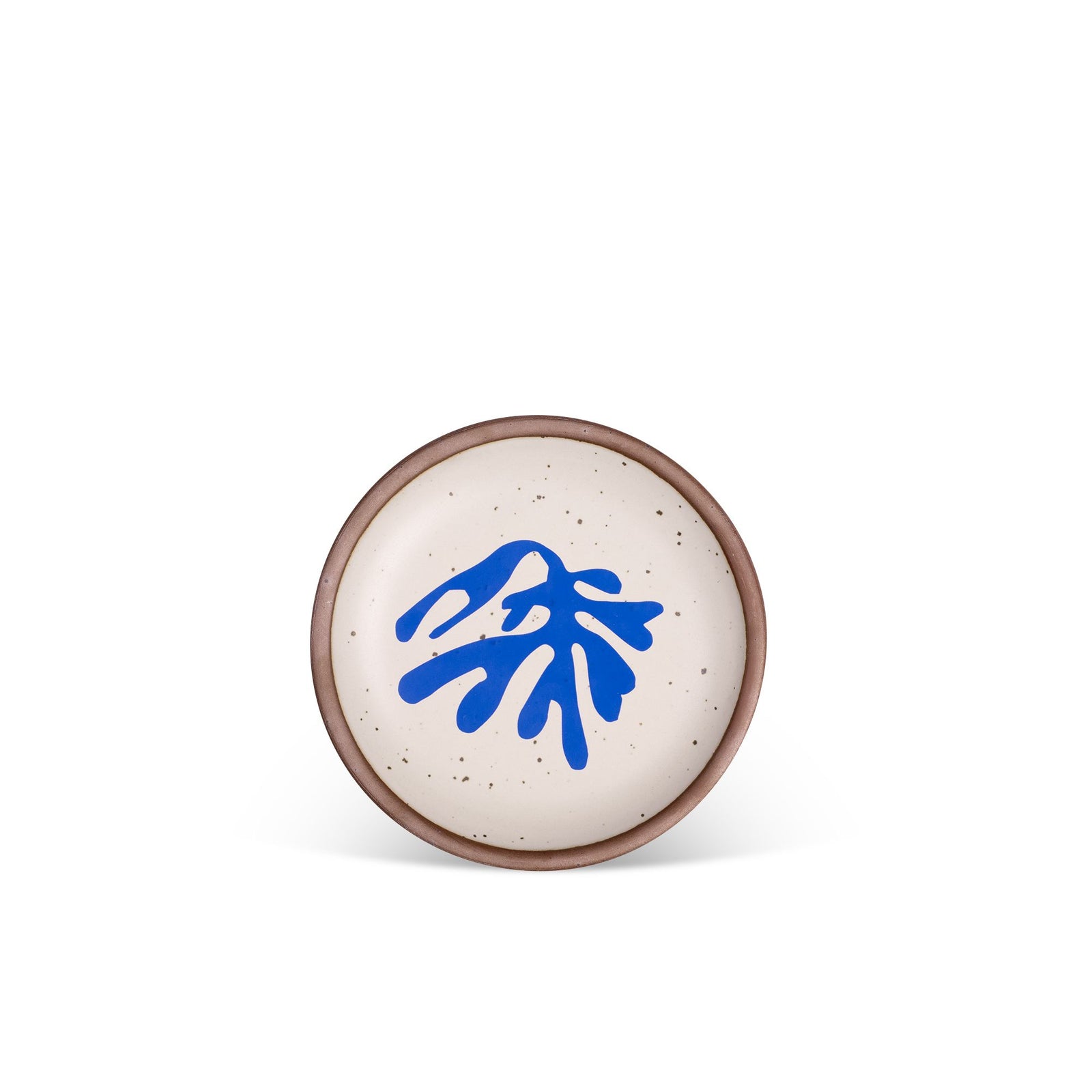 Ceramic plate with a minimalist design features a matte off-white speckled glaze and a bold cobalt blue abstract shape in the center, set against a plain white background.