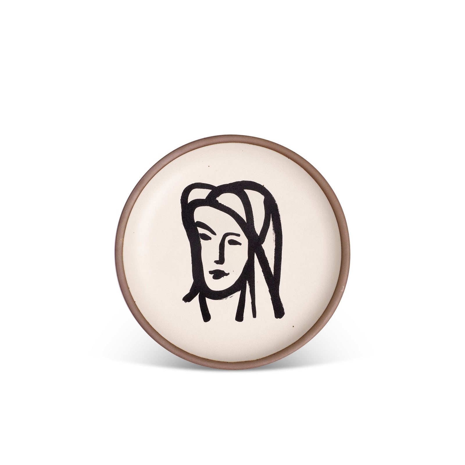 A round ceramic plate featuring a minimalist black line drawing of a face, set against a white background with a subtle brown rim.