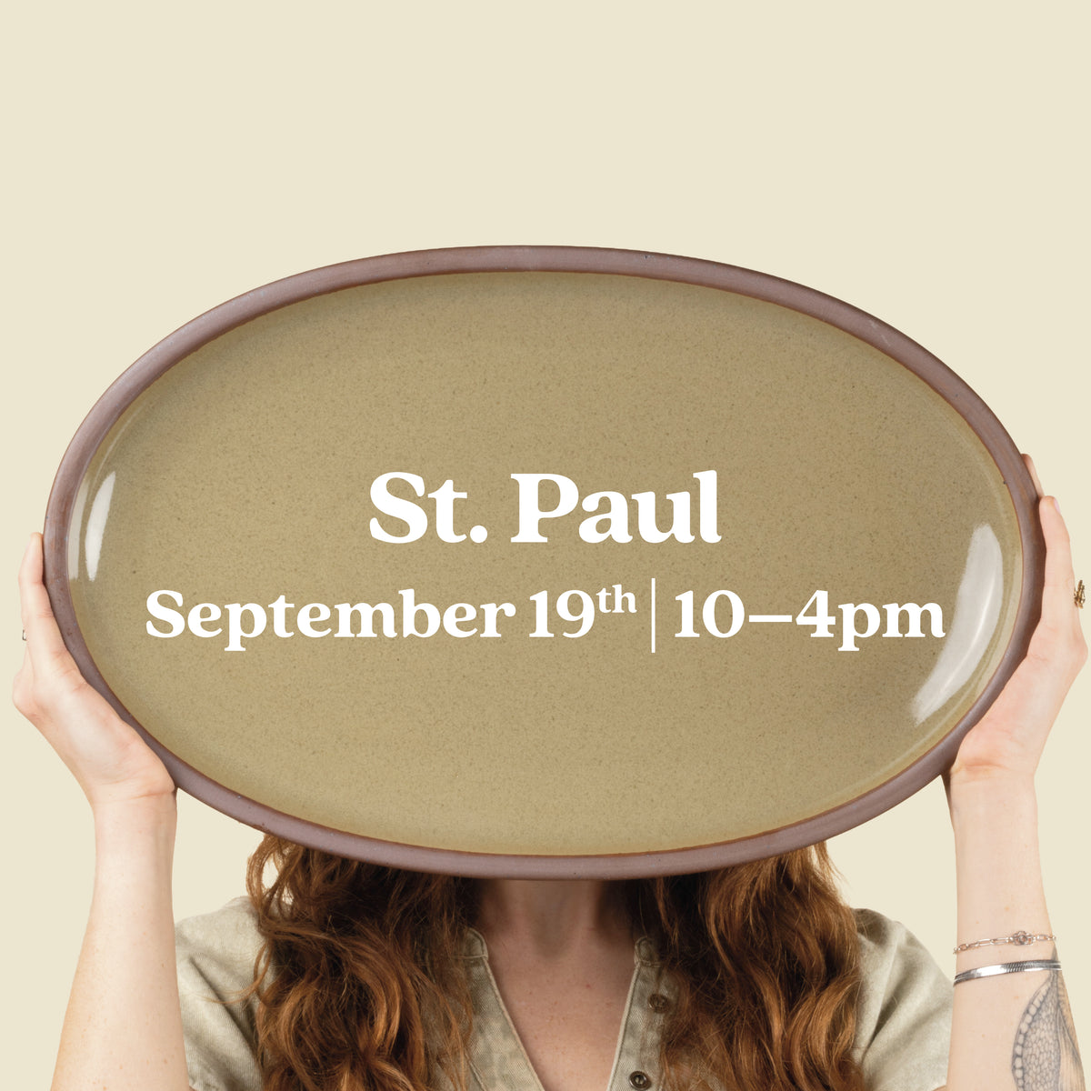 Person holds up a large oval platter with text overlay that reads "St. Paul September 19th 10-4pm"