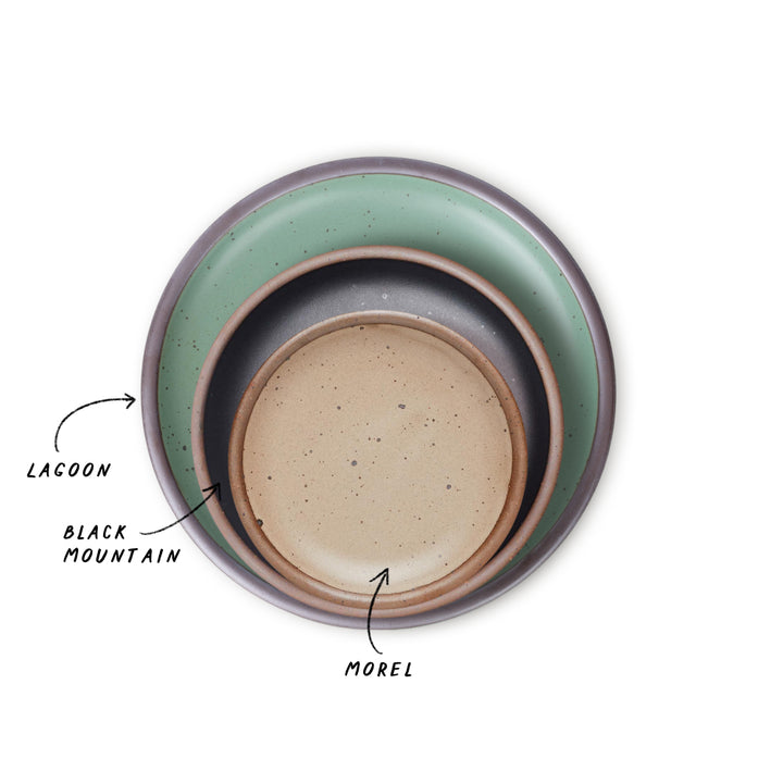 Three nested ceramic plates with different colors, green, black, and pale brown with labels on a white background