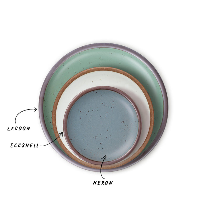 Three nested ceramic plates with different colors, green, cool white, and blue-grey with labels on a white background
