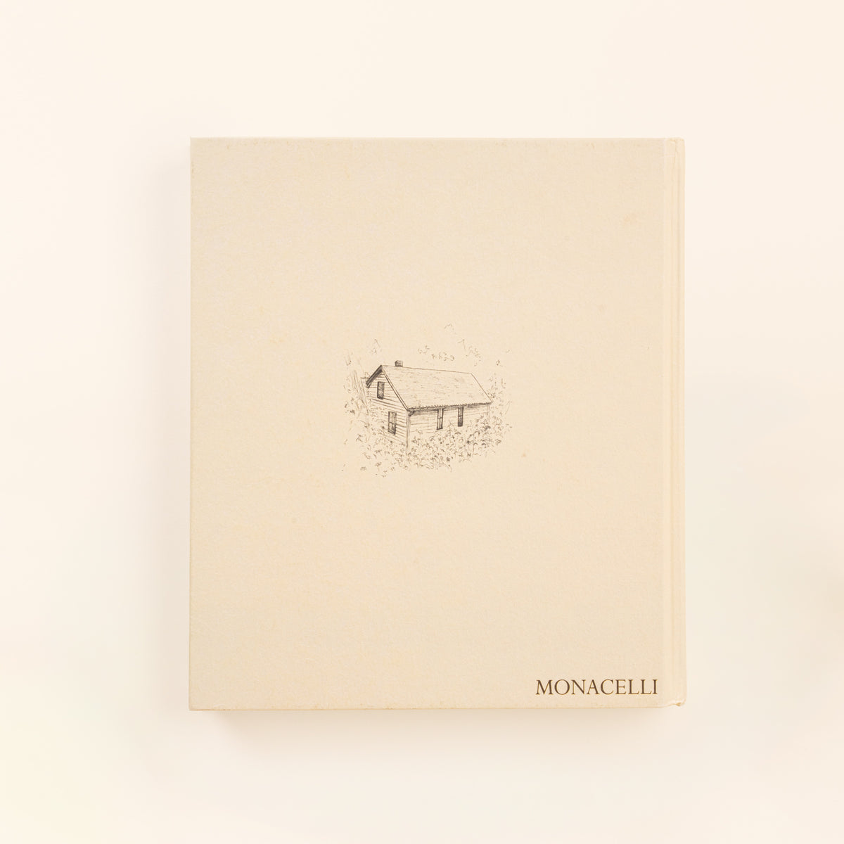 Back cover of a cream hardcover book featuring a small illustration of a house in the center and the Monacelli publisher logo at the bottom.