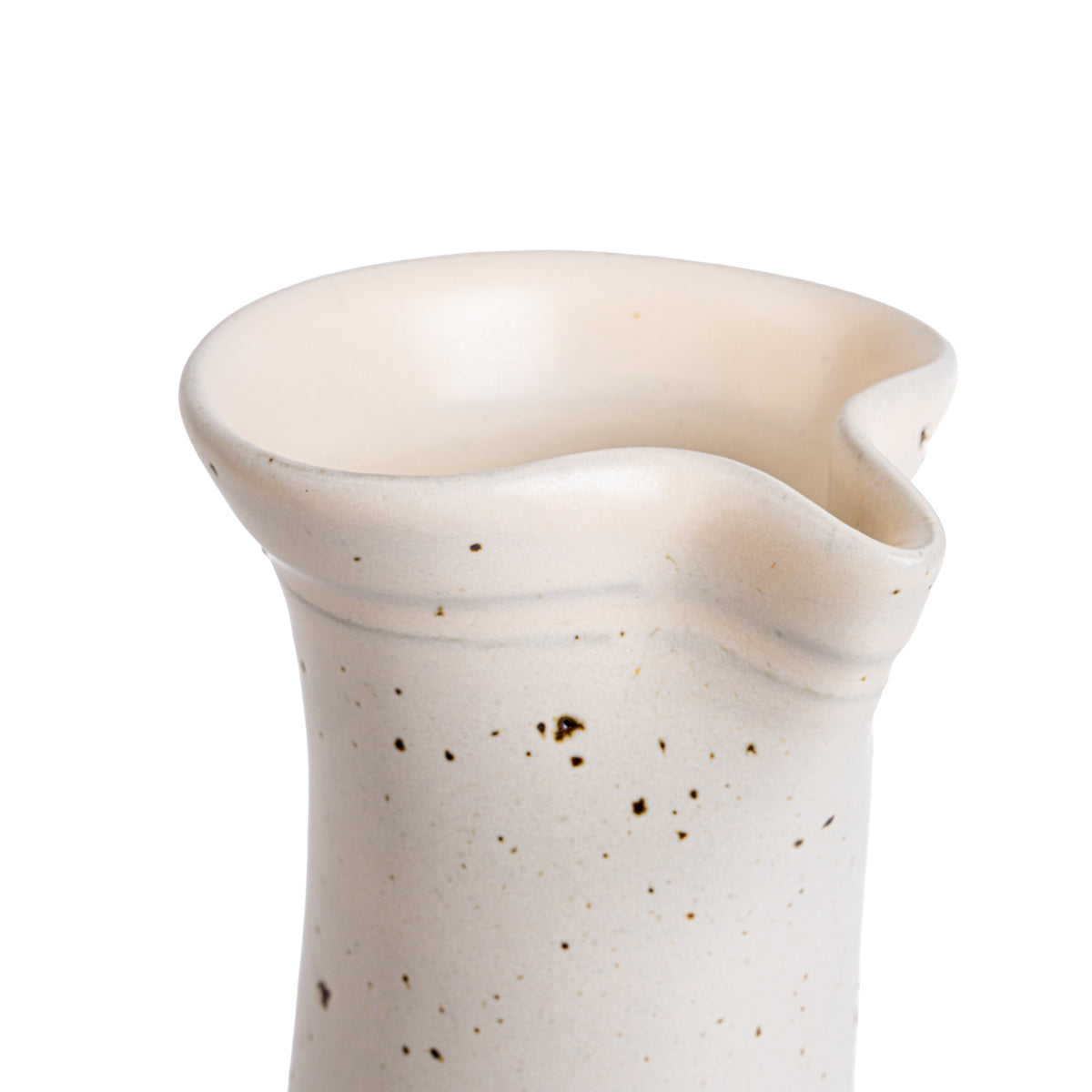 Closeup of a hand thrown spout on a ceramic carafe in an off-white color
