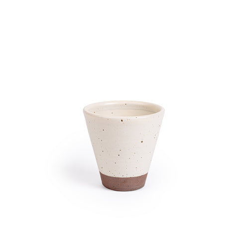 A tapered cup in an off-white color with iron speckles and unglazed base.