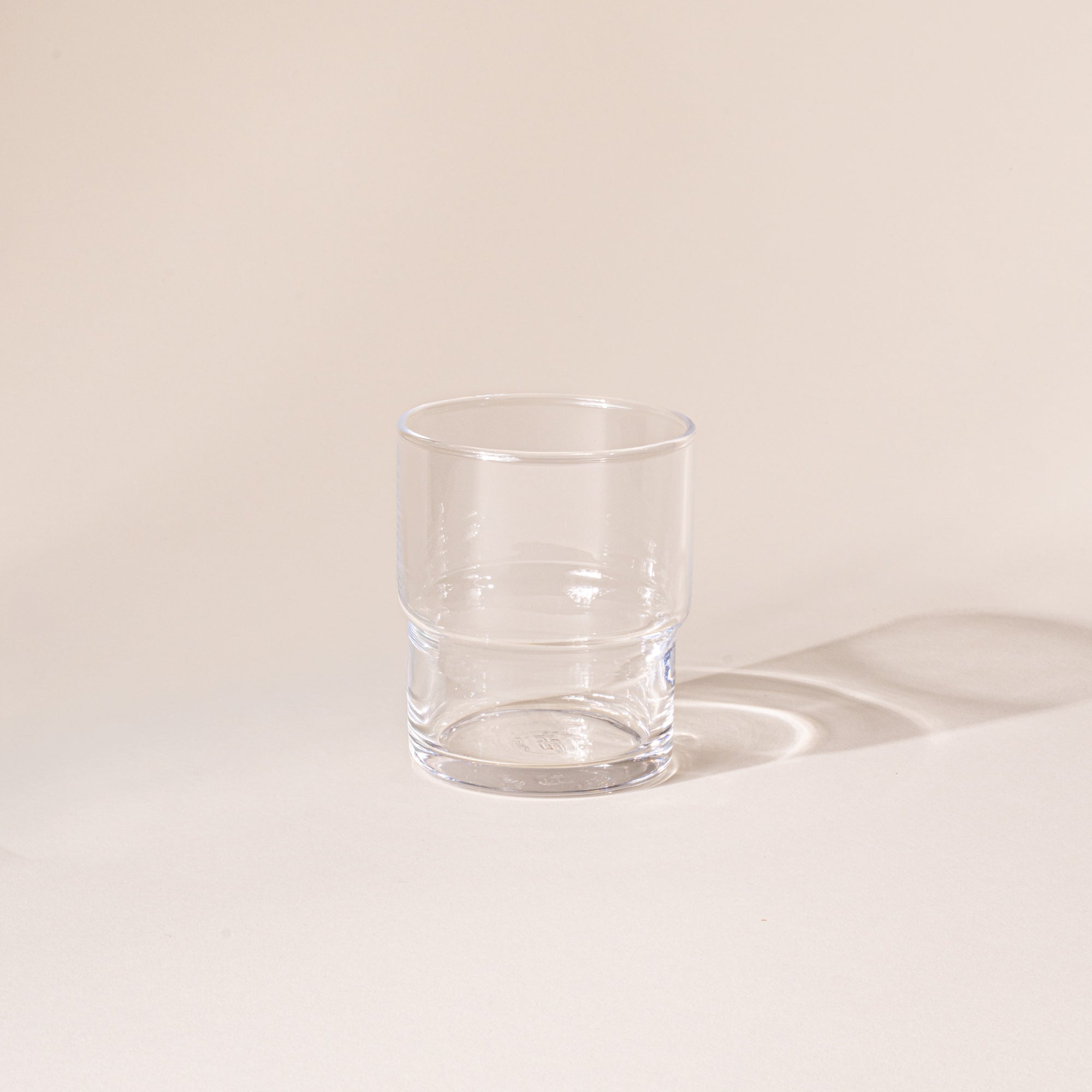 Clear cylindrical glass with a wider top half with a narrower bottom half