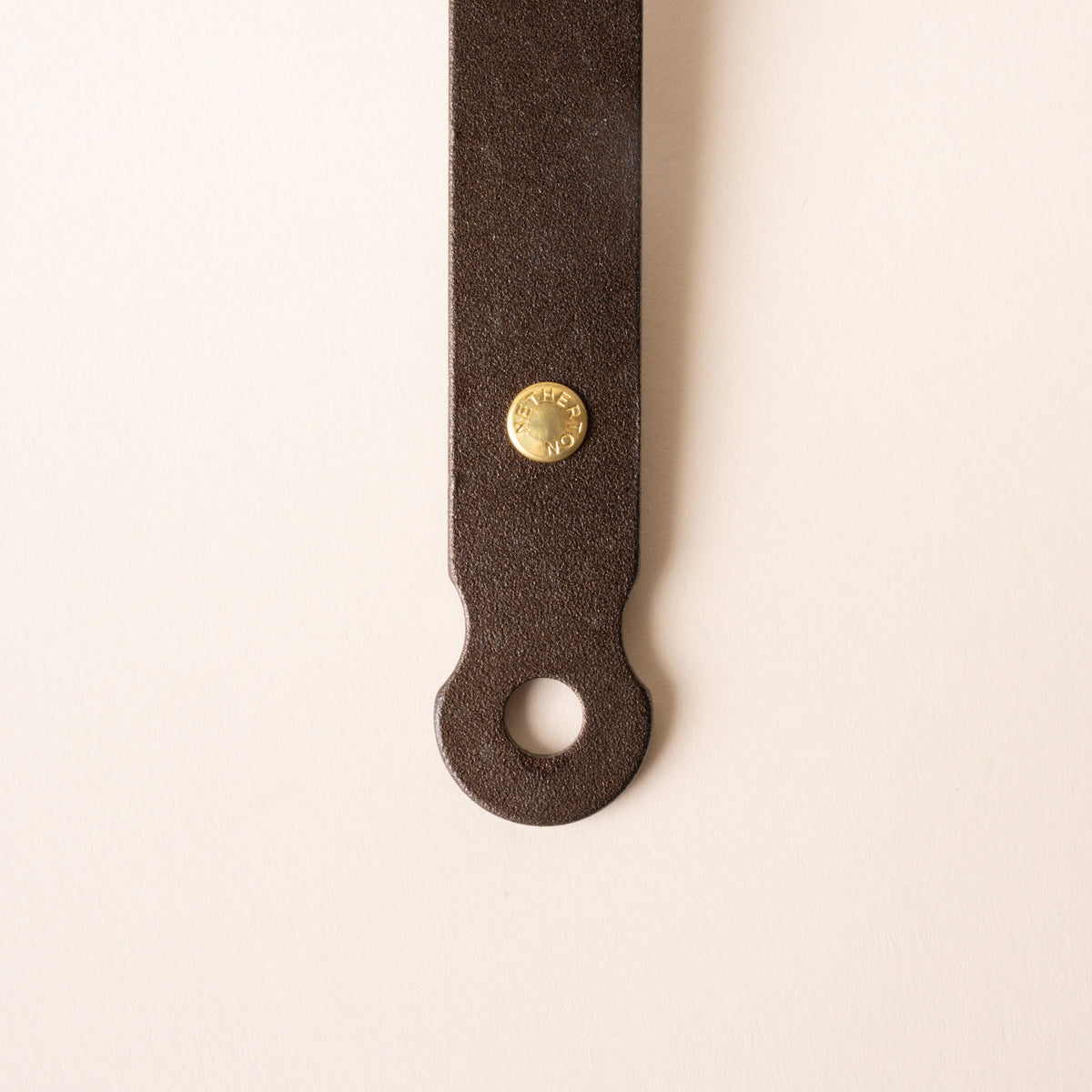 Close up of the end of a handle of a cast iron ladle with a hole for hanging