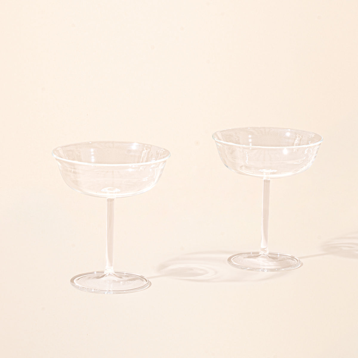 Two empty clear coupe glasses