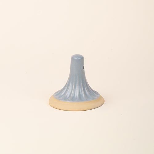 A light blue ceramic cookie stamp with a cream colored base