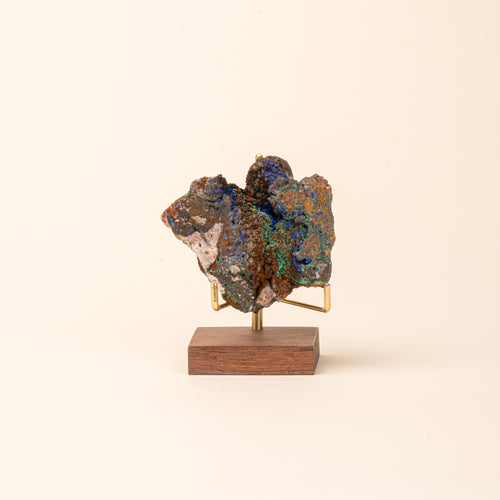 Azurite displayed on a wood display stand with brass prongs.