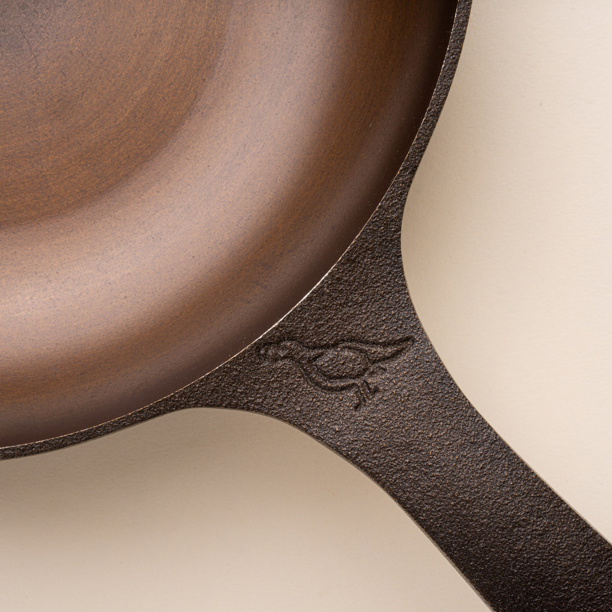 Closeup of the stamp on a handle of a small cast iron skillet.