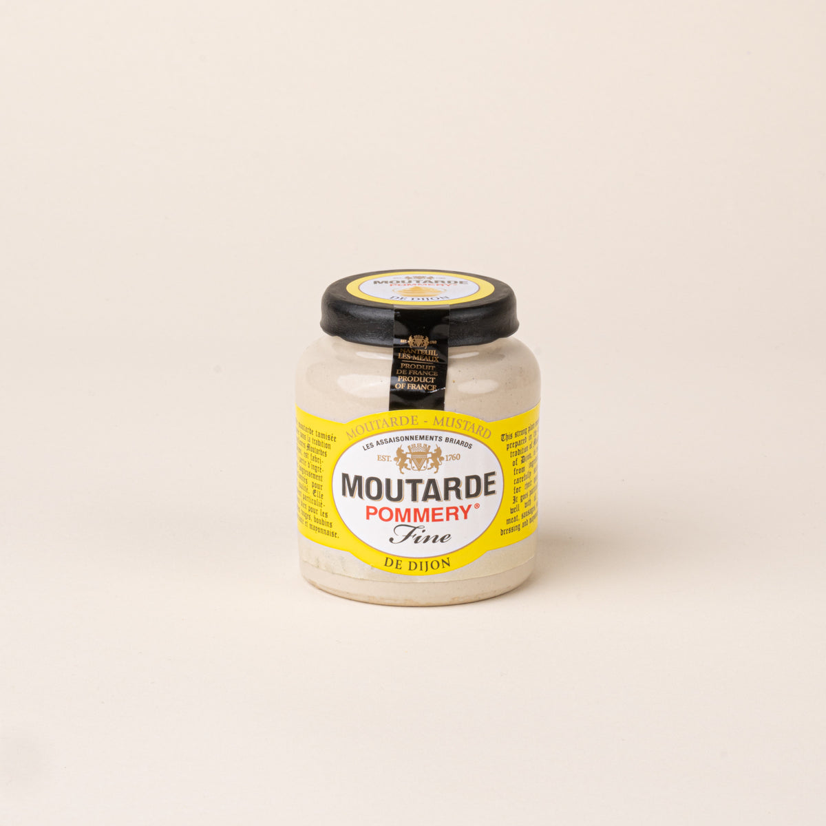Glass jar of Pommery Fine Dijon mustard with a black lid and yellow and white label on a cream background.