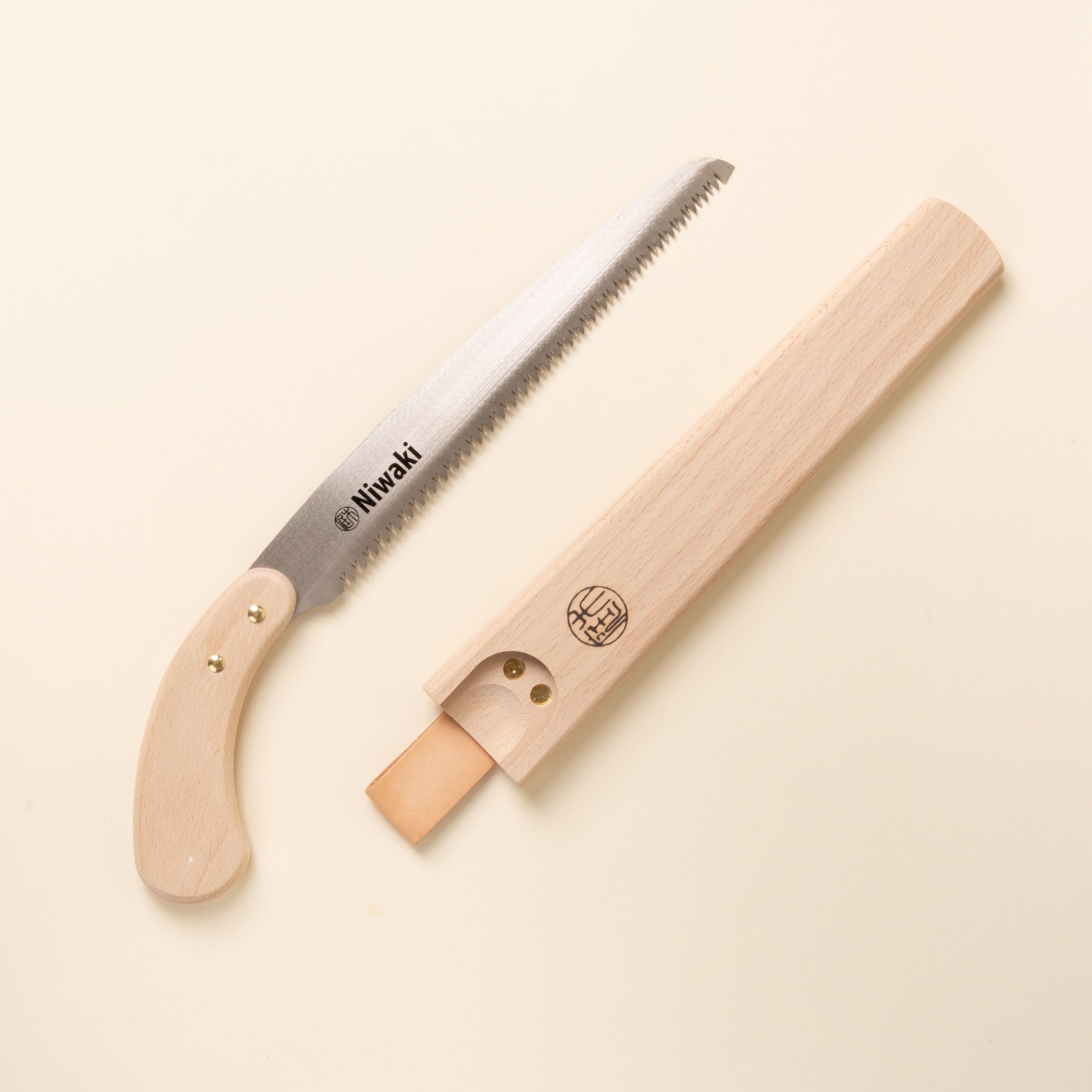 Niwaki wooden-handled pruning saw with protective wooden sheath.