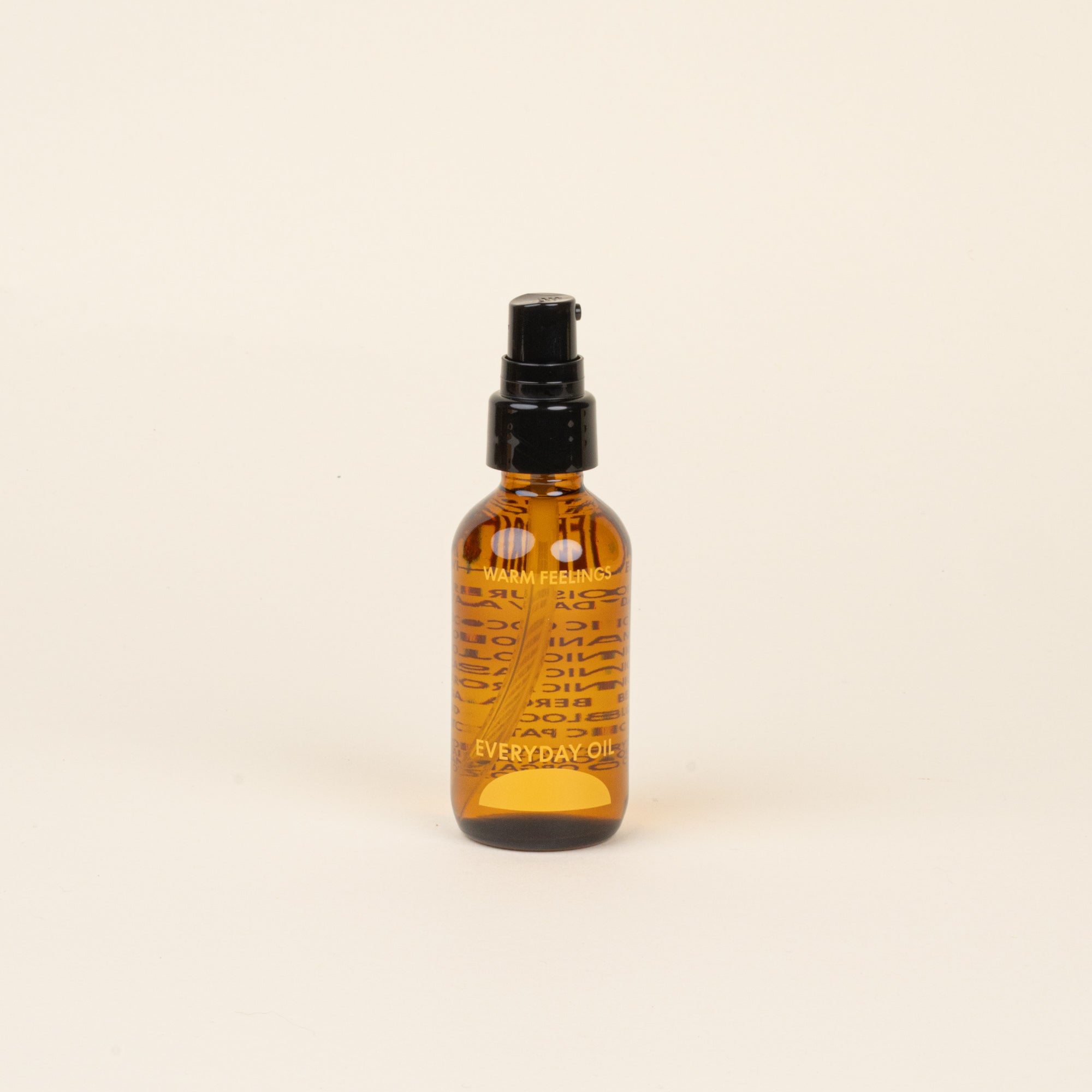 Amber glass bottle with black cap and label that reads 'Warm Feelings Everyday Oil' on a beige background.