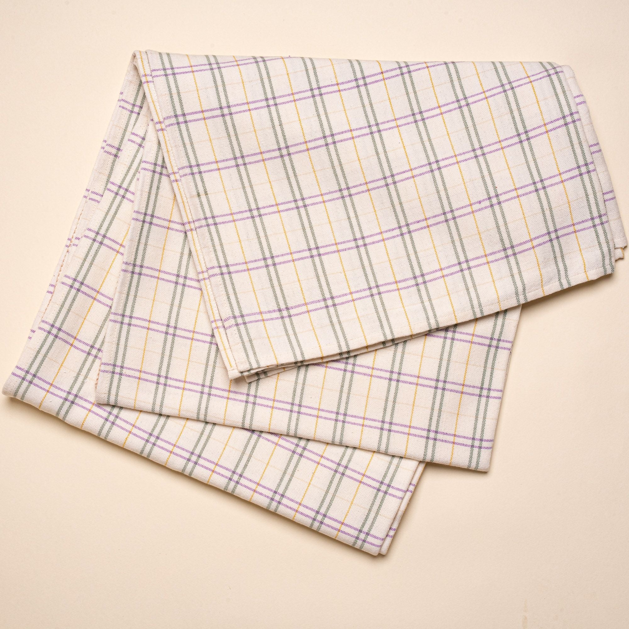 A plaid tablecloth with lines of purple, yellow, and dark teal.