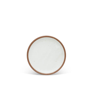A dessert sized ceramic plate in a cool white color featuring iron speckles and an unglazed rim.