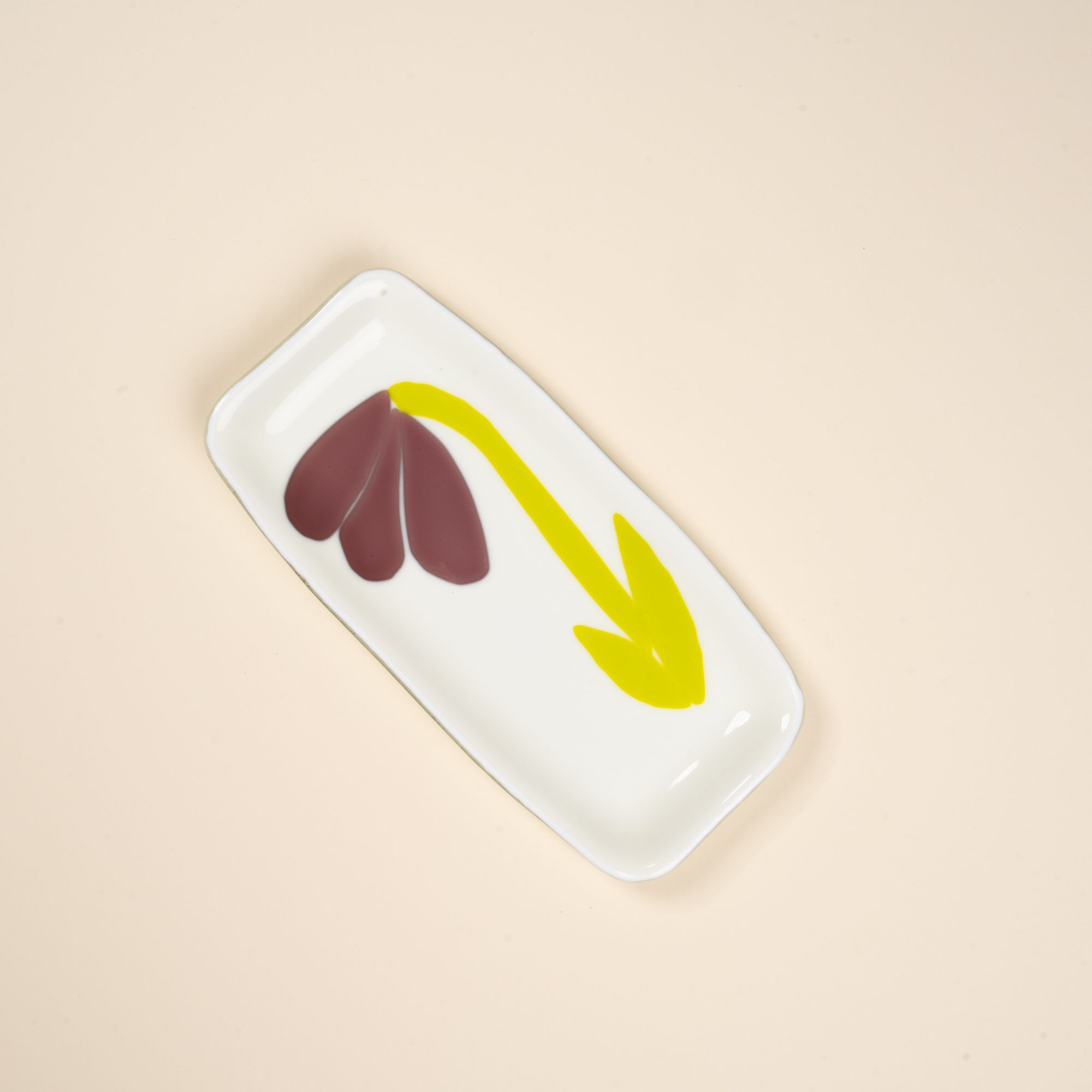 A white rectangular glass catchall tray with a design featuring a minimal purple flower with green stem.