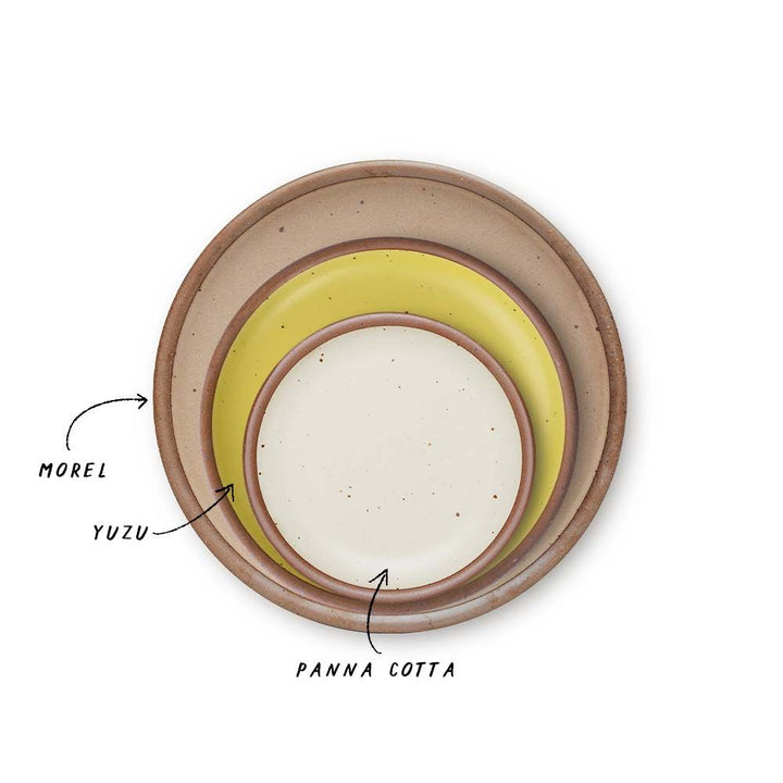 A stack of 3 plates in Dinner, Side, and Cake sizes in a warm pale brown, zesty yellow colors, and warm off-white.