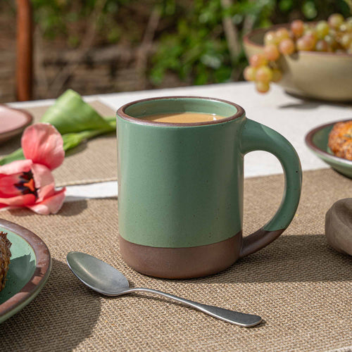 A large ceramic mug with straight walls and sturdy handle in a viridian green glaze with a matte finish.