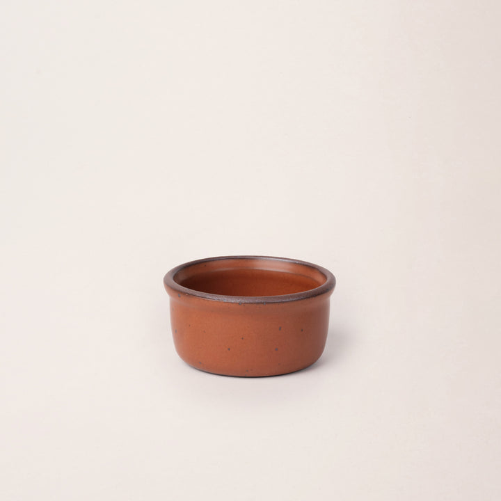 Small ceramic ramekin in a cool terracotta color with an unglazed rim