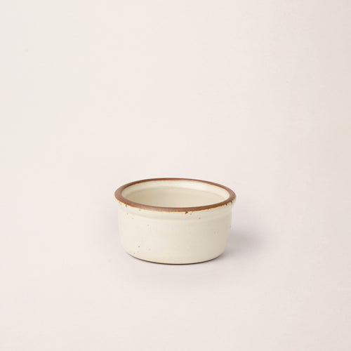 Small ceramic ramekin in a warm off-white color with an unglazed rim