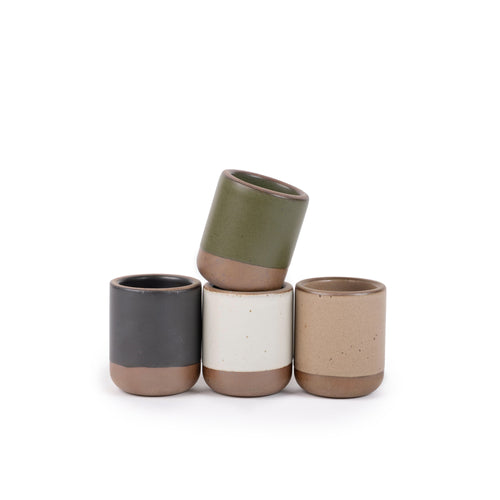 A set of 4 small, short ceramic mug cups in olive green, graphite black, off-white, and warm pale brown colors featuring iron speckles and unglazed rim