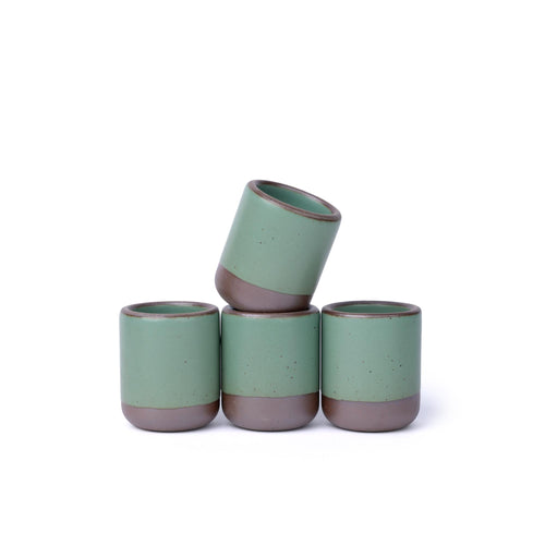 Four handleless ceramic cups for small pours in a viridian green glaze with a matte finish.