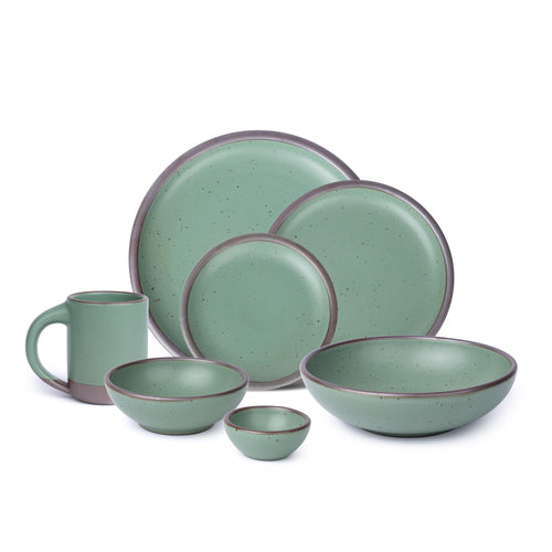 A 7-piece tablesetting set with bowls, plates and a mug in a viridian green glaze with a matte finish.