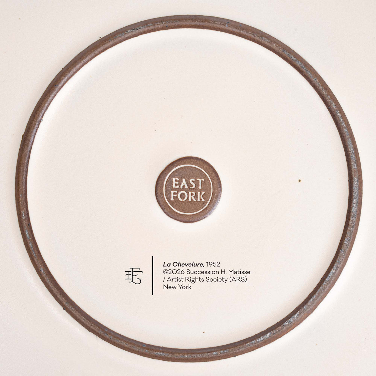 The underside of a ceramic serving platter by EAST FORK with the copyright and title of Henri Matisse's artwork, La Chevelure.