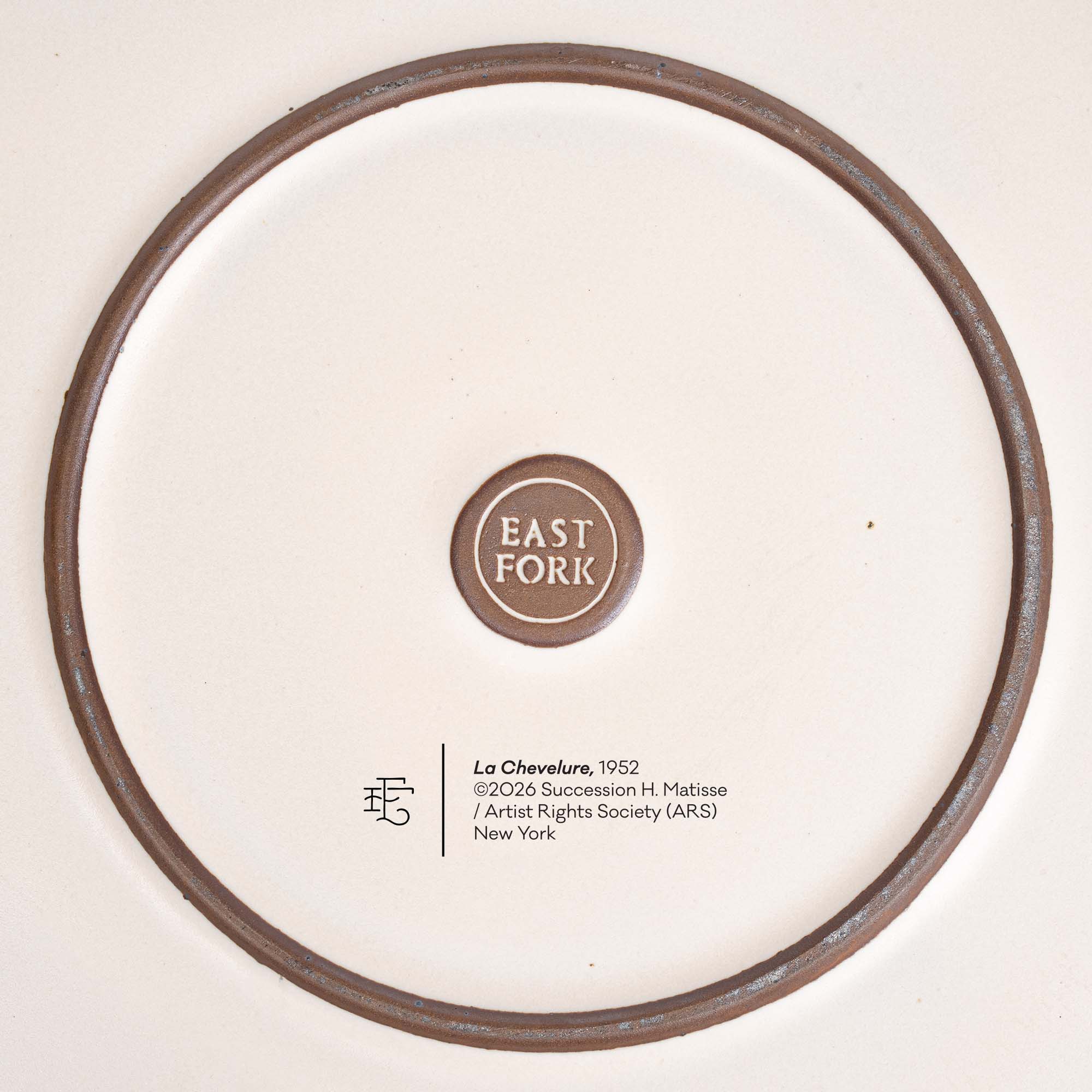 The underside of a ceramic serving platter by EAST FORK with the copyright and title of Henri Matisse's artwork, La Chevelure.