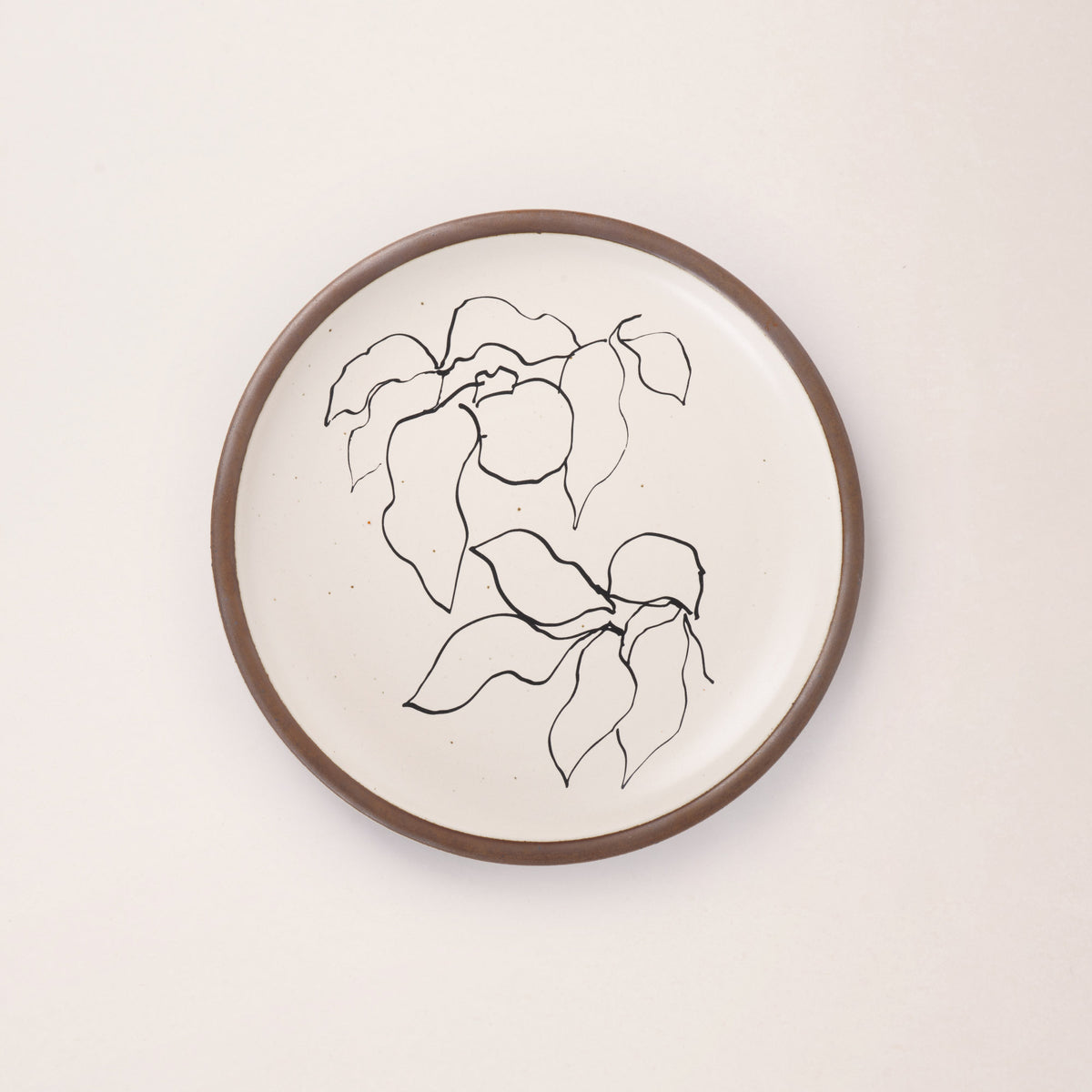 A warm off-white ceramic dinner plate featuring a black Verve illustration by Henri Matisse.