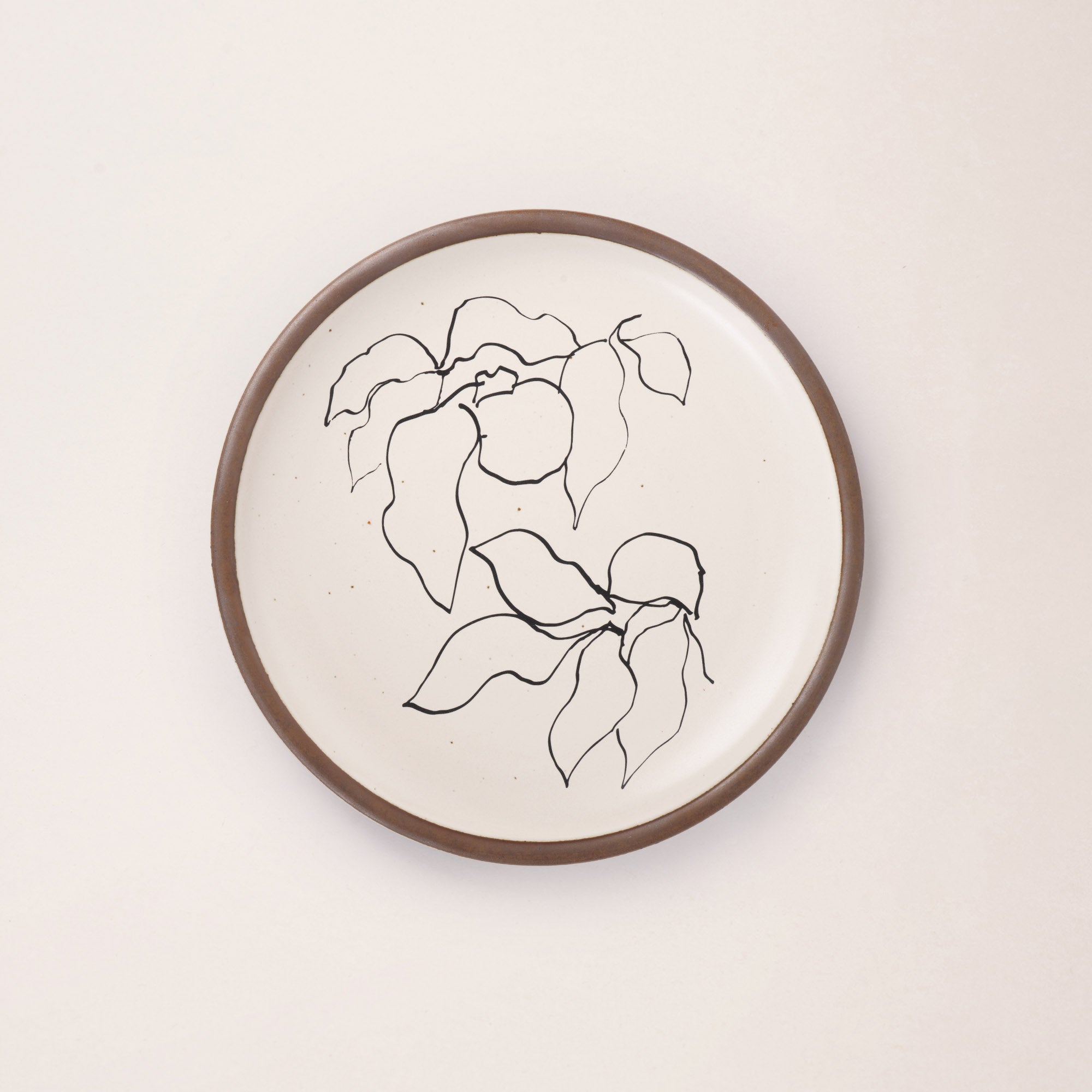 A warm off-white ceramic dinner plate featuring a black Verve illustration by Henri Matisse.