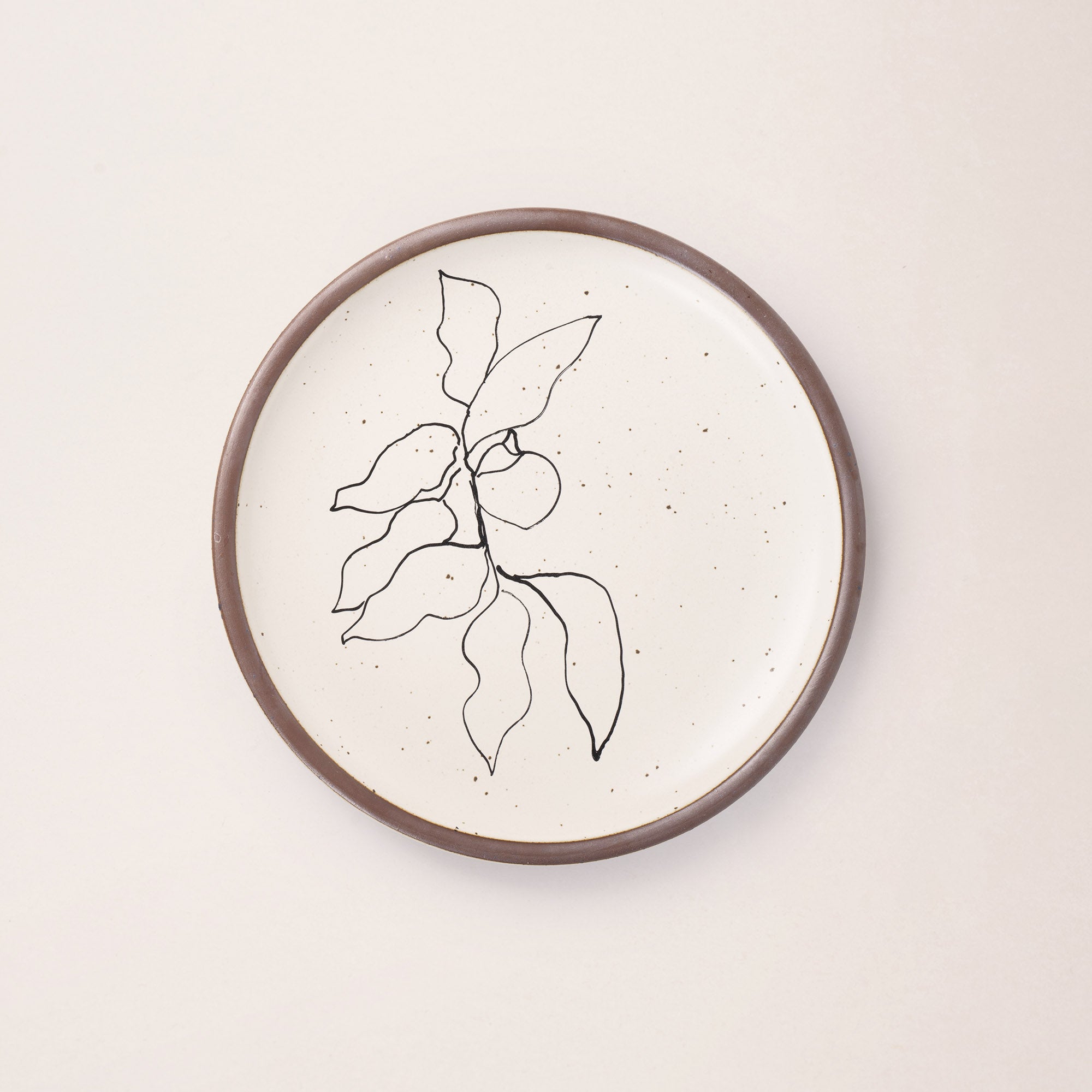 A warm off-white ceramic dinner plate featuring a black Verve illustration by Henri Matisse.