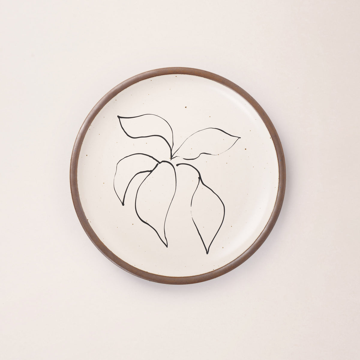 A warm off-white ceramic dinner plate featuring a black Verve illustration by Henri Matisse.
