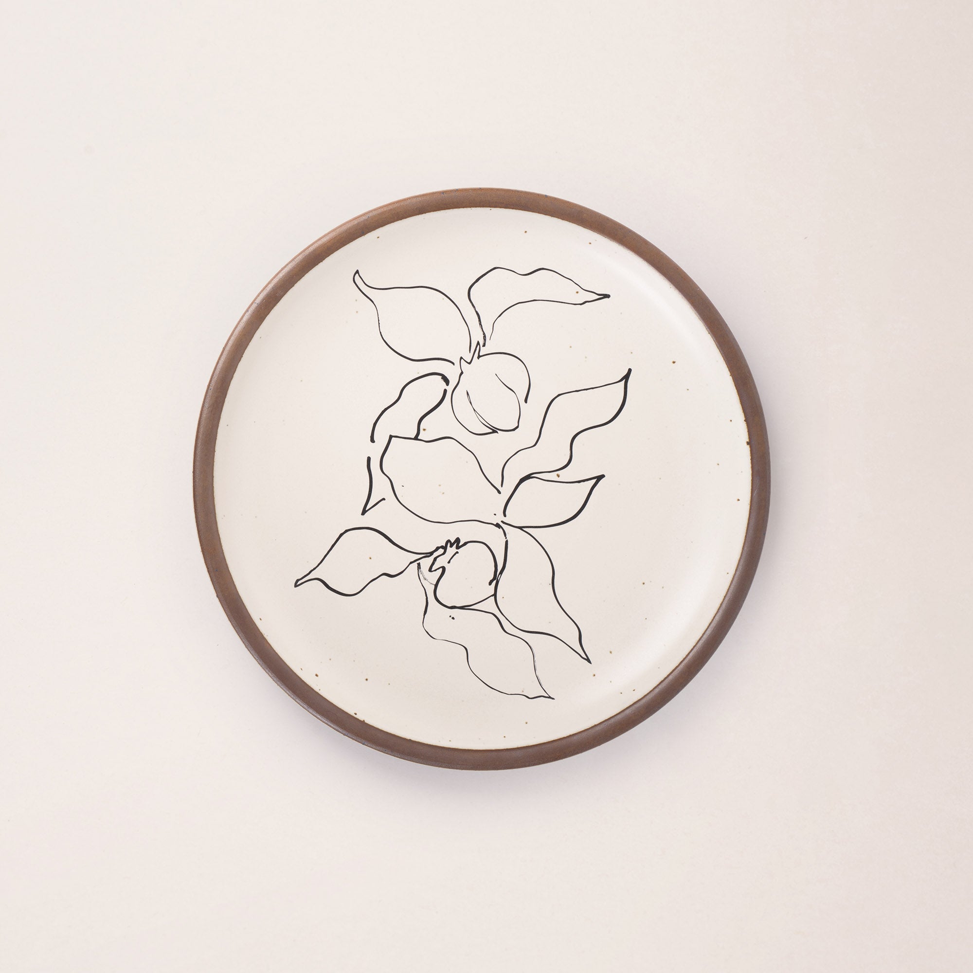 A warm off-white ceramic dinner plate featuring a black Verve illustration by Henri Matisse.