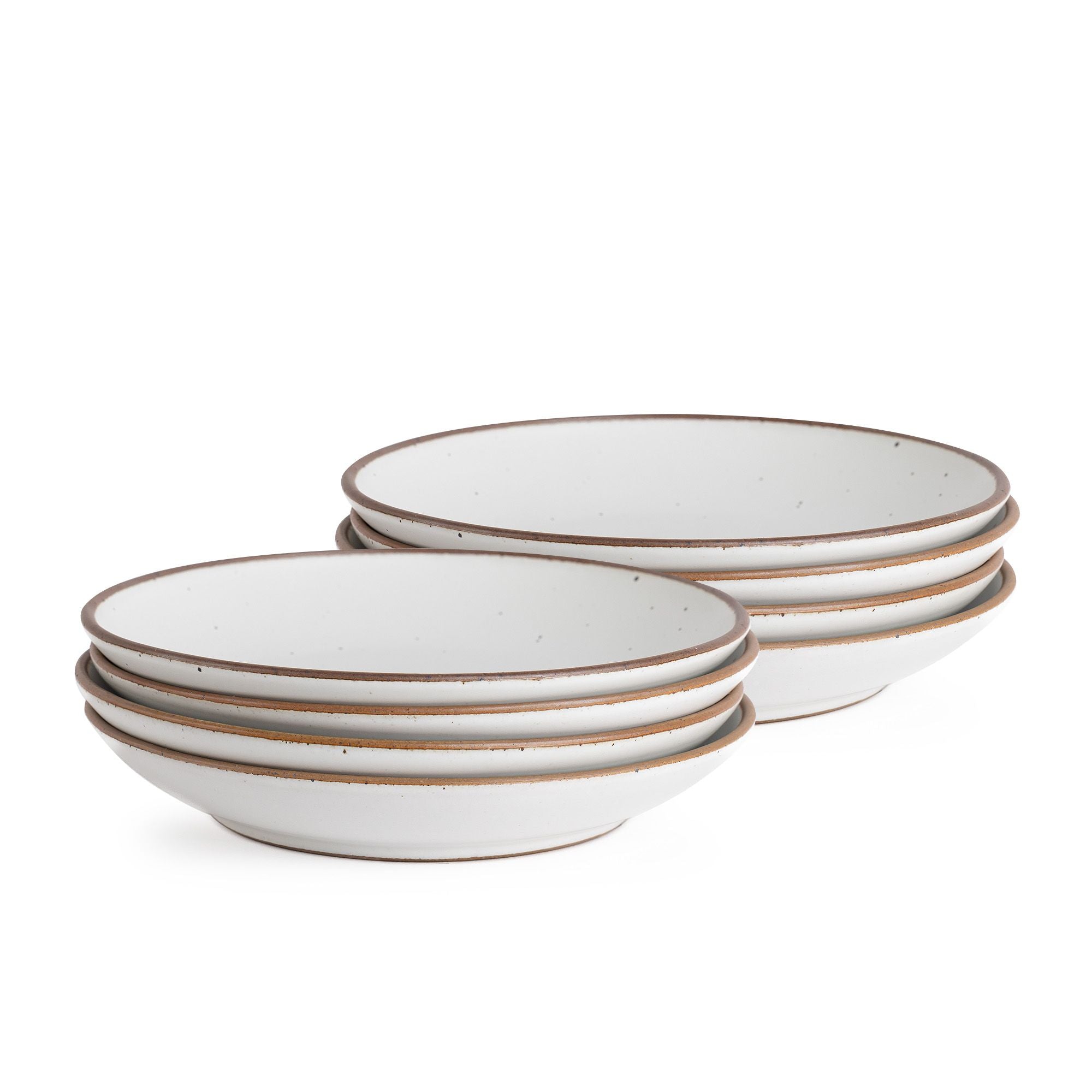 A stack of six shallow ceramic bowls in a light speckled glaze with brown rims, displayed against a plain white background.