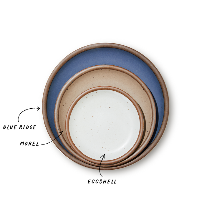 A stack of 3 plates in Dinner, Side, and Cake sizes in a navy, warm light brown, and white colors.