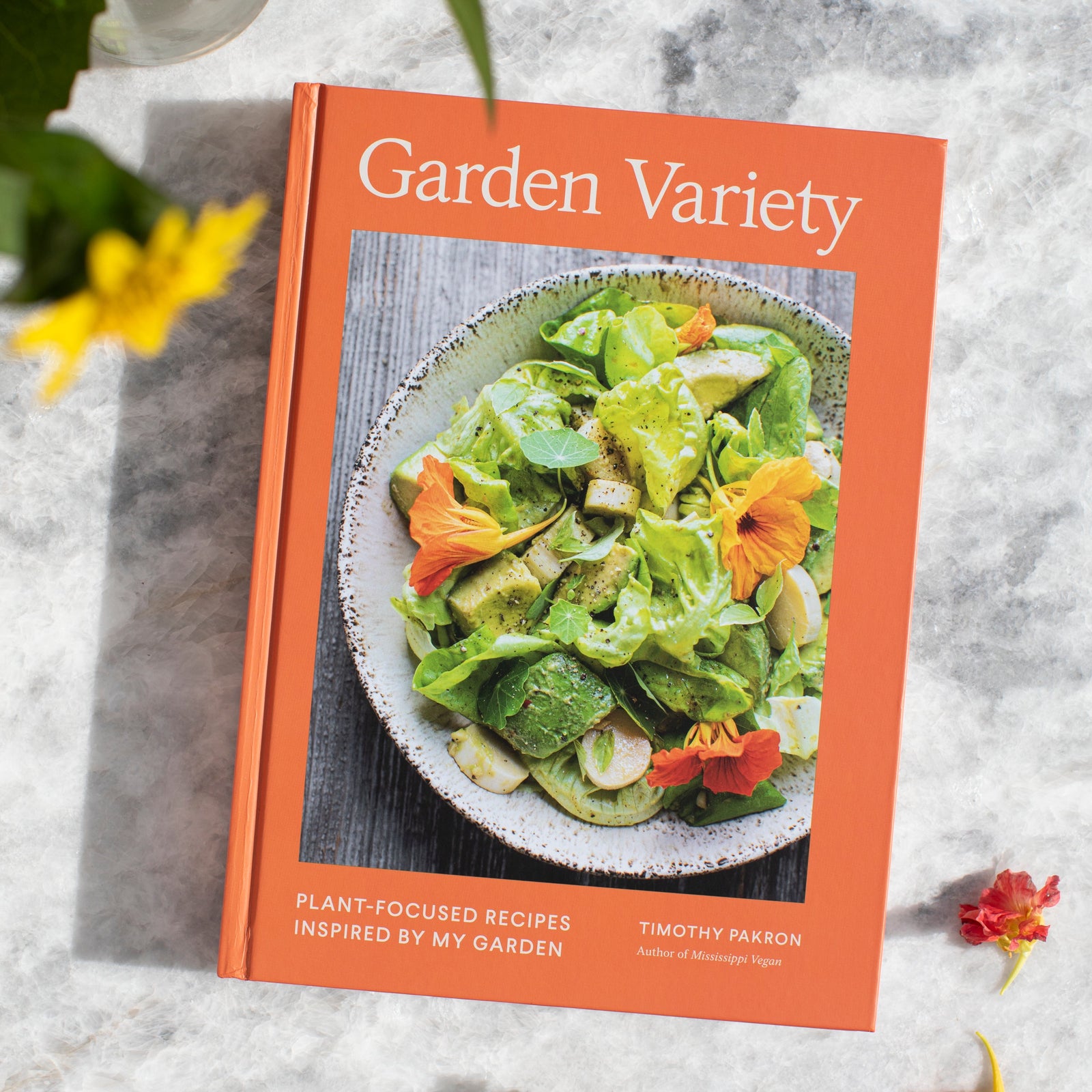 An overhead view of a cookbook titled Garden Variety by Timothy Pakron with a photo of a bowl filled with veggies.
