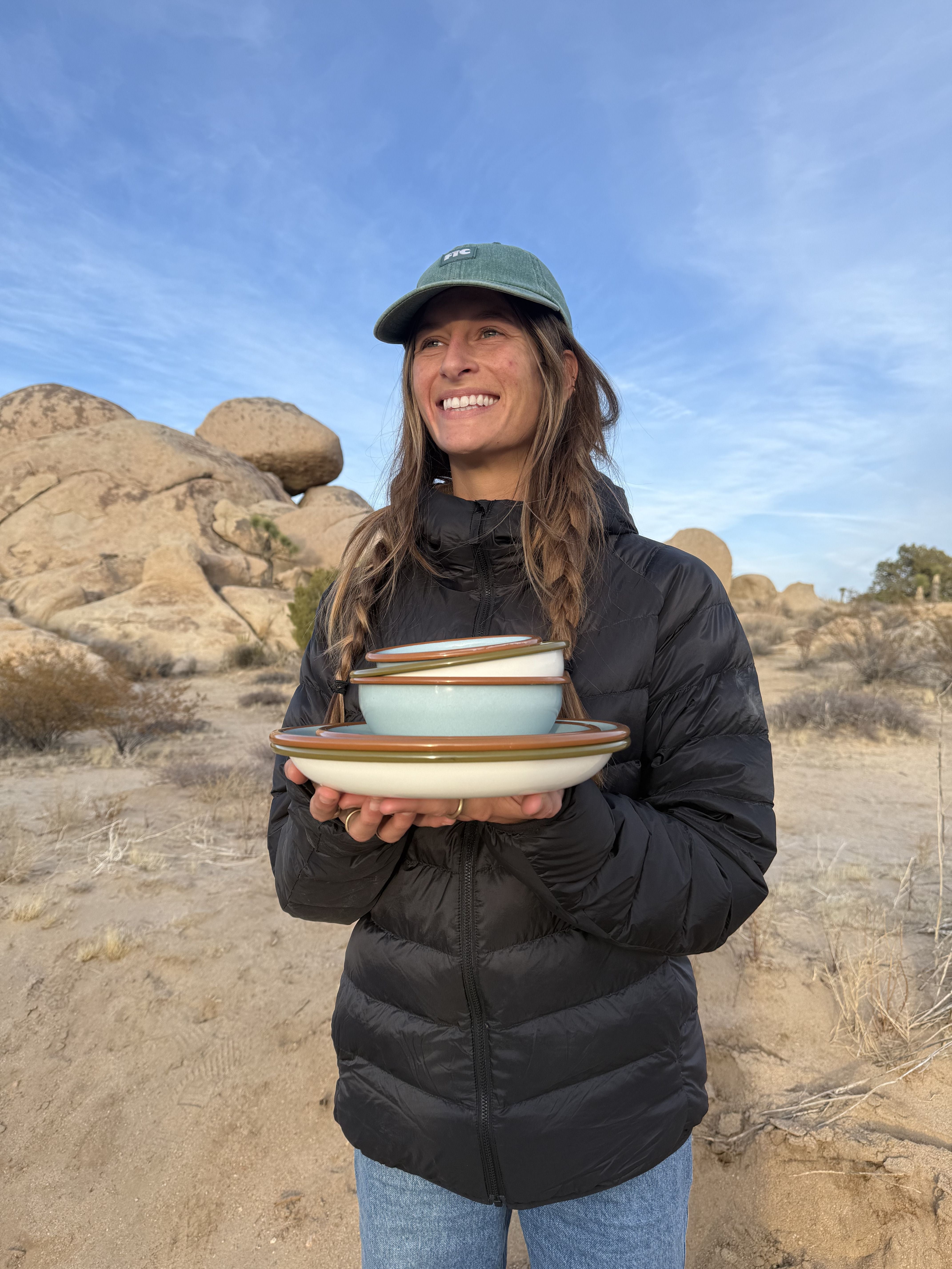 A woman holds East Fork enamelware in the California desert