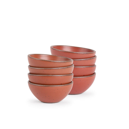A stack of 8 small dessert sized rounded ceramic bowls in a cool burnt terracotta color featuring iron speckles and an unglazed rim