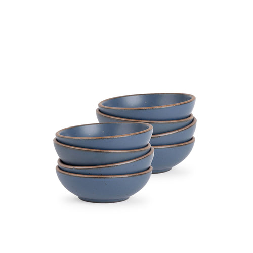 A stack of 8 small shallow ceramic bowls in a cool, medium blue color featuring iron speckles and an unglazed rim