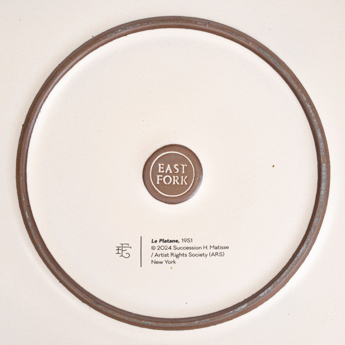 The back of the Serving Platter with an East Fork stamp with a small decal of information about the artwork.