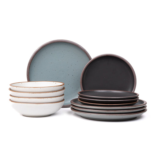 4 ceramic dinner plates in blue-grey, 4 side plates in graphite black, and 4 shallow dinner bowls in white with iron speckles and unglazed rims.