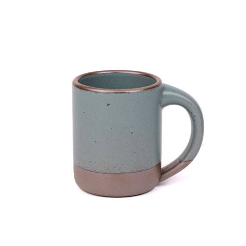 A big sized ceramic mug with handle in a zesty yellow color featuring iron speckles and unglazed rim and bottom base.