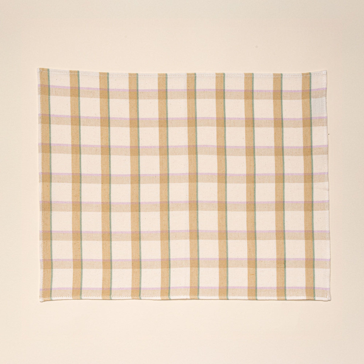 A rectangular plaid placemat with lines of pastel pink, teal, and peach.